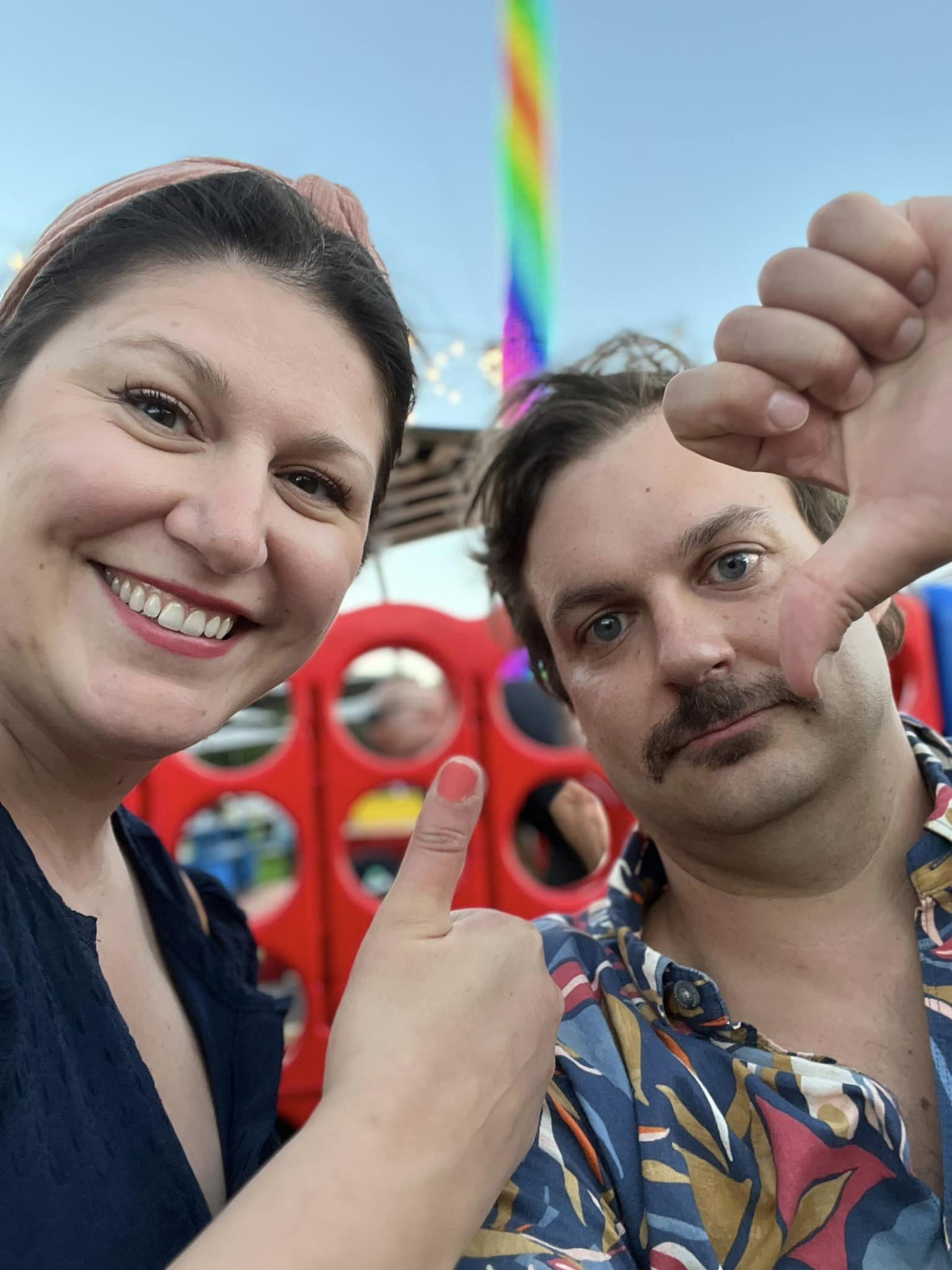 A beautiful and triumphant woman celebrating her win alongside a pouting man