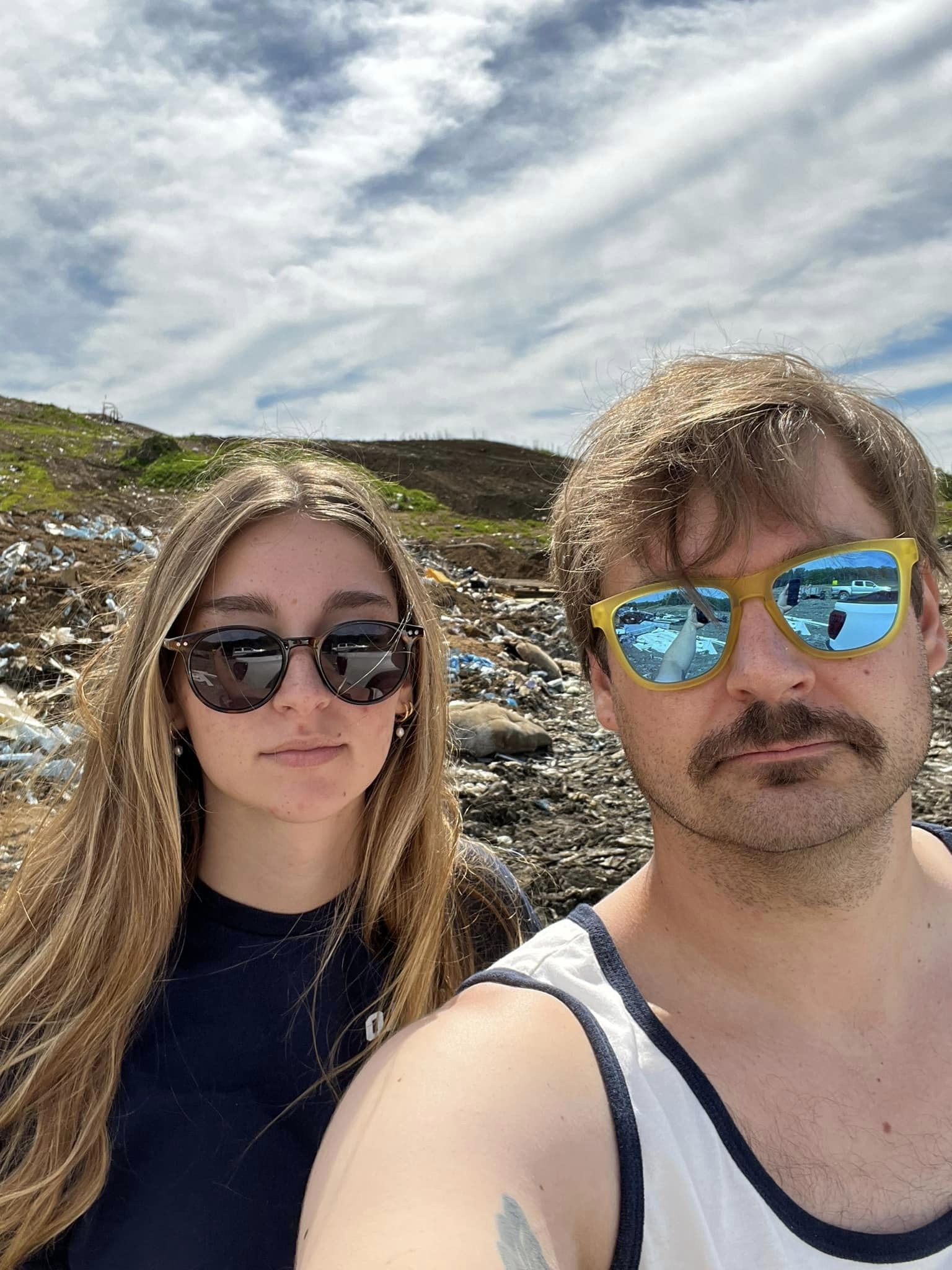 Two unhappy workers dropping garbage off at the landfill